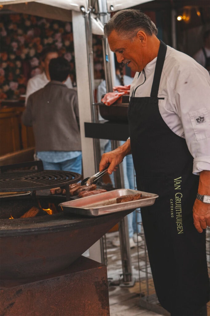 Chef bereidt vlees op de grill bij Heerlijk Heesch.