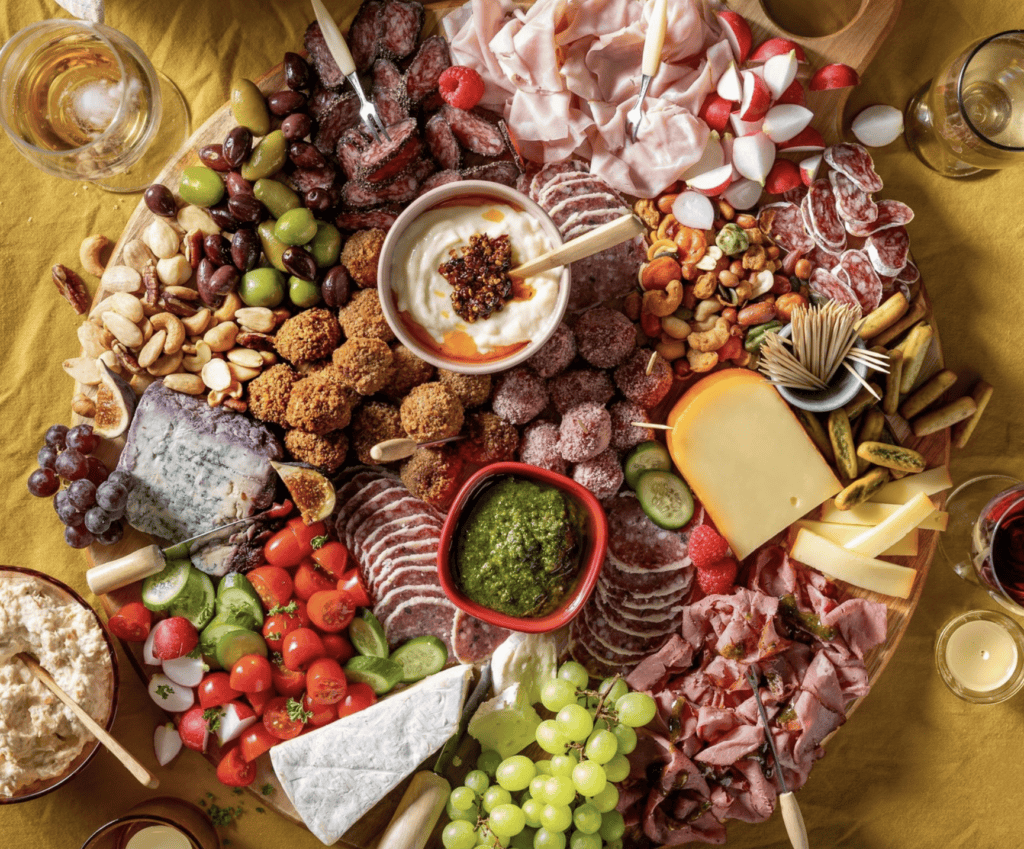 Uitgebreide food line-up met kaas, vleeswaren, fruit en snacks voor feestdagen.