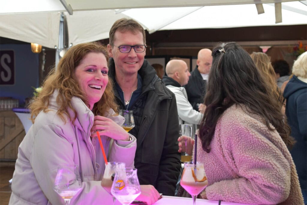 Mensen genieten van drankjes op een terras tijdens Heerlijk Heesch.