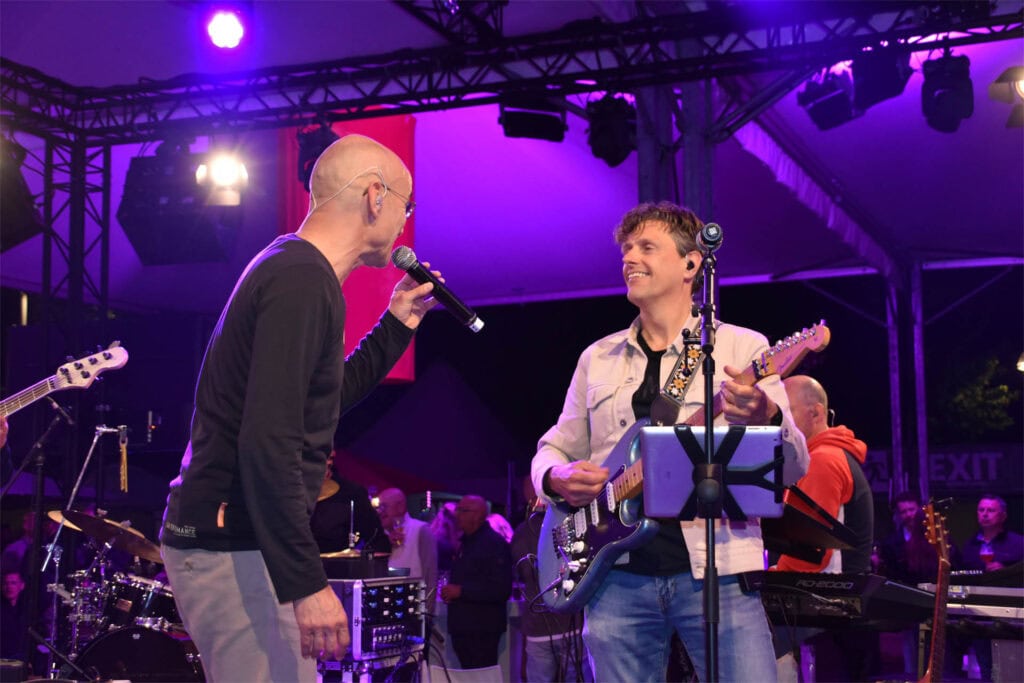 Optreden tijdens Heerlijk Heesch met muzikanten op het podium.