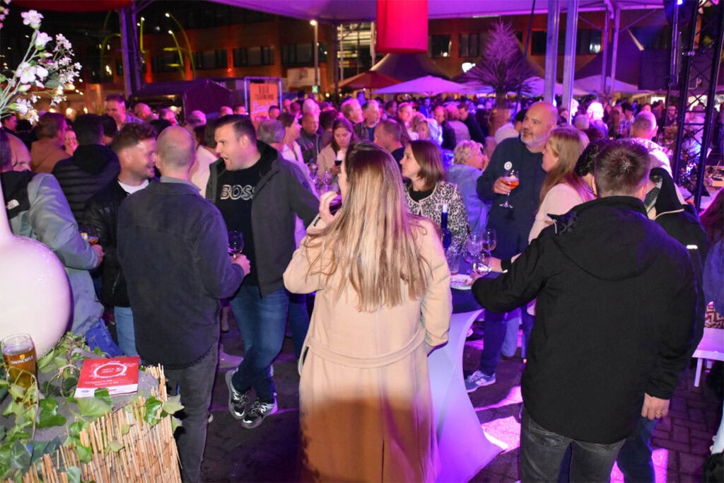 Gezellig drukke avond met mensen die genieten van drankjes en muziek.