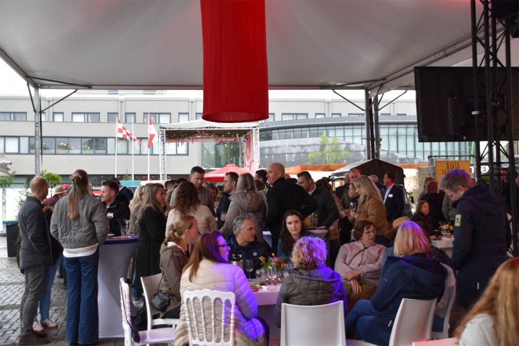 Bezoekers genieten van een evenement onder een grote tent in Heesch.