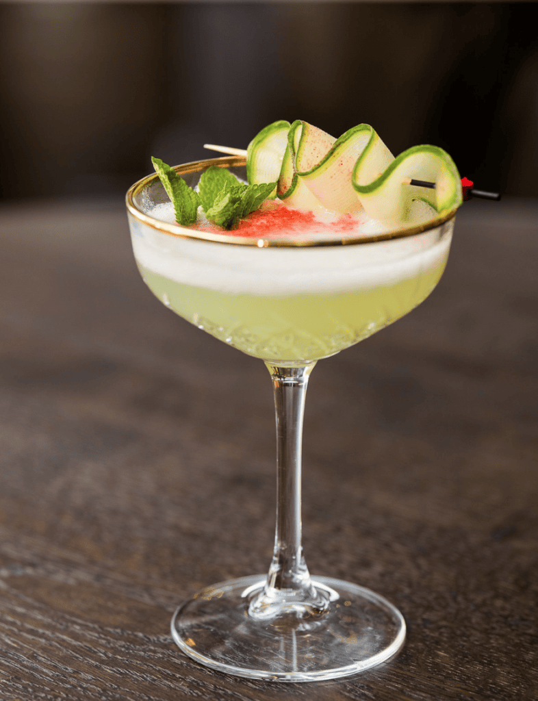 Cocktail met komkommer, munt en fruitige garnering.
