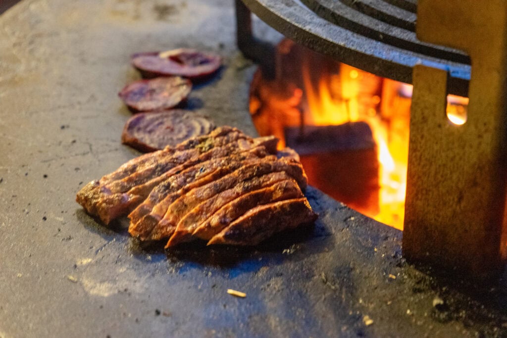 Gegrilde steaks bereiden op houtskool in een traditionele barbecue.