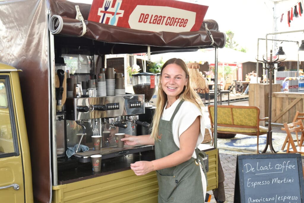Heerlijk Heesch koffie stand met lachende barista en espresso-apparaat.