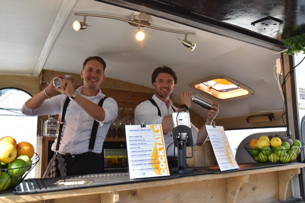 Heerlijk Heesch barpersoneel serveert cocktails op een gezellige locatie.