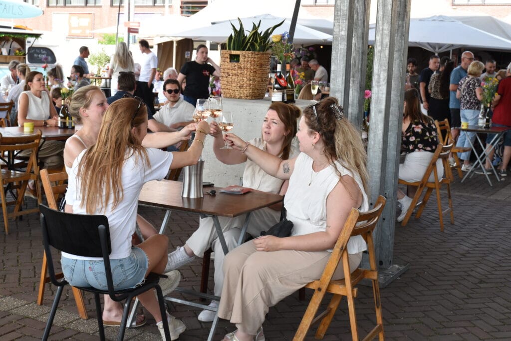 Gezellig terras in Heesch met vrienden die samen genieten van drankjes en goede sfeer.